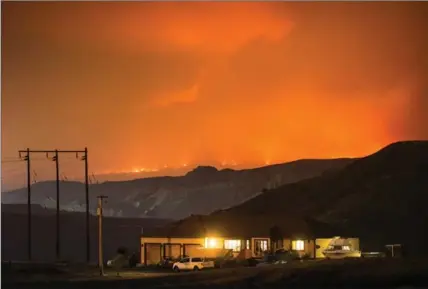  ?? DARRYL DYCK, THE CANADIAN PRESS ?? A wildfire burns on a mountain in the distance east of Cache Creek in Boston Flats, B.C., in the early morning hours of Monday.