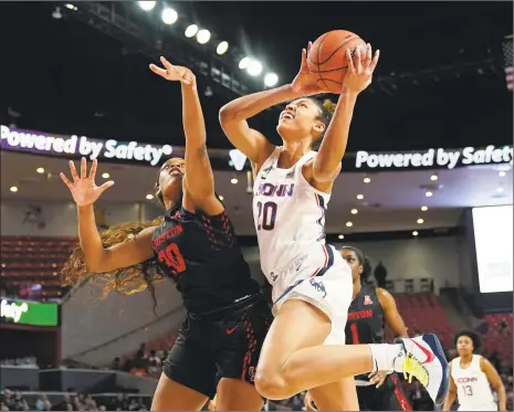  ?? David J. Phillip / Associated Press ?? Connecticu­t’s Olivia Nelson-Ododa (20) goes up for a shot as Houston’s Tatyana Hill (30) defends during the first half of an NCAA women’s basketball game on Saturday in Houston.