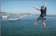  ??  ?? A boy jumps off a jetty into the Teign estuary July 21 in Shaldon.