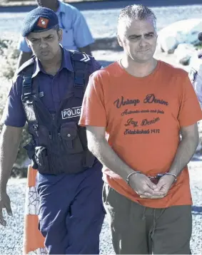  ?? Picture: GARY RAMAGE ?? FRAIL: John Nikolic being led into court in Nadi.