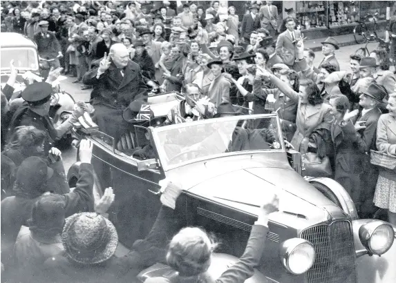  ??  ?? > Winston Churchill gives the Victory sign to cheering crowds in Queen Street after the Freedom ceremony at Cardiff City Hall on July 16, 1948