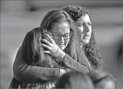  ?? AP PHOTO ?? Students released from a lockdown embrace following a shooting at Marjory Stoneman Douglas High School in Parkland, Fla., Wednesday.