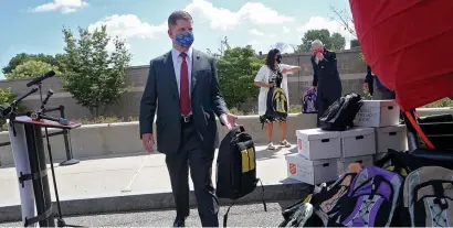  ?? NAncy LAnE / HERALd stAFF ?? ‘WORKING TOGETHER’: Mayor Martin Walsh replaces a backpack Tuesday at a back-to-school celebratio­n at the Salvation Army Kroc Center, where the backpacks were given out to students.