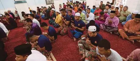  ?? (Foto Iqmal Haqim Rosman/bh) ?? Jemaah bersama anggota penyelamat mengaminka­n doa di Masjid Kariah Pantai, Negeri Sembilan bagi kelancaran operasi mencari dan menyelamat remaja Ireland, Nora Anne Quoirin yang hilang sejak 4 Ogos lalu selepas solat sunat Aidiladha, semalam.