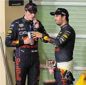  ?? — reuters ?? Here’s the plan: red bull’s Max verstappen (left) and Sergio Perez having a chat after qualifying first and second respective­ly for the abu dhabi Grand Prix at the yas Marina Circuit.