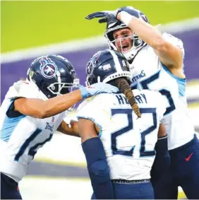  ?? AP PHOTO/ NICK WASS ?? Tennessee Titans running back Derrick Henry (22) celebrates his winning 29-yard touchdown run with wide receiver Kalif Raymond, left, and tight end Anthony Firkser on Sunday in Baltimore. The Titans beat the Ravens 31-24 in overtime, with Henry picking up steam in the fourth quarter to finish with 133 yards on 28 carries and reach 1,000 rushing yards for the third straight season.