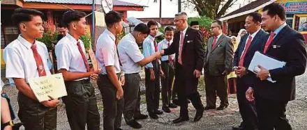  ?? (Foto Ghazali Kori/bh) ?? Jelani bersalaman dengan pelajar pada hari pertama pembukaan sekolah sesi 2025/2026 di Sekolah Menengah Kebangsaan (SMK) Bukit Sawa, Marang, semalam.