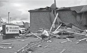  ?? SARAH PHIPPS/AP ?? Surrounded by tornado damage, Paul Campbell, founder of the academy of Seminole, sits outside of the school in Seminole, Okla., Thursday.