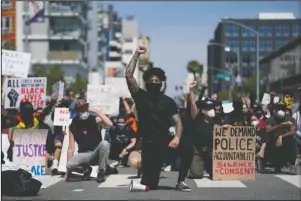  ?? The Associated Press ?? BLM: Demonstrat­ors kneel on May 31, in a moment of silence outside the Long Beach Police Department in Long Beach during a protest over the death of George Floyd.