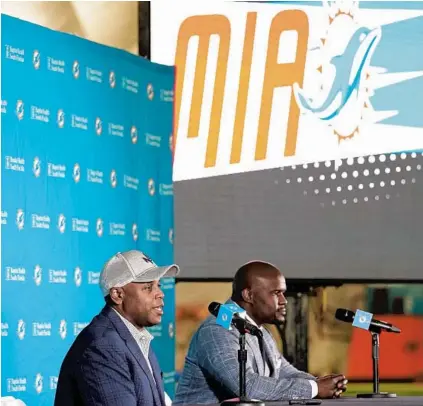  ?? LYNNE SLADKY/AP ?? Dolphins general manager Chris Grier, left, and coach Brian Flores speak during a news conference about players chosen by the Dolphins in the first round of the NFL football draft, April 30, in Davie, Fla.