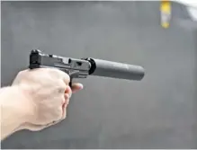  ?? STAFF PHOTO BY ANGELA LEWIS FOSTER ?? Chris Dempsey fires a gun with a silencer at Shooters Depot on Shallowfor­d Road. A House bill would roll back state prohibitio­ns on firearm silencers.