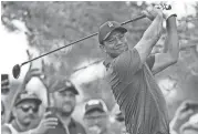  ??  ?? Tiger Woods follows through during the pro-am for the Memorial golf tournament. DAVID DERMER/AP