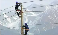  ?? CAI ZENGLE / FOR CHINA DAILY ?? Employees of State Grid erect power transmissi­on lines in the Xinjiang Uygur autonomous region.