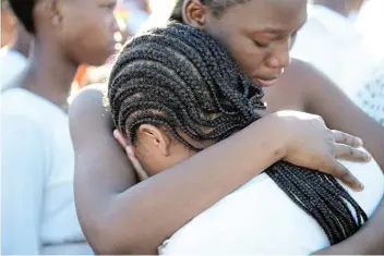  ?? Picture: MARK ANDREWS ?? HUGS OF COMFORT: Youngsters comfort each other outside the Enyobeni tavern where friends and relatives died on Sunday.