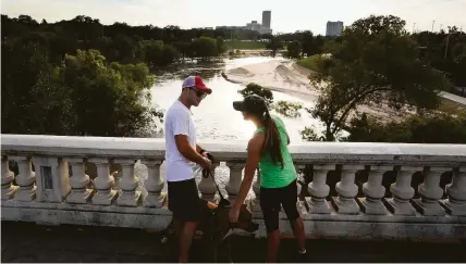  ?? Jon Shapley / Houston Chronicle file ?? Andrew Hoffmann and Allison Hubert walk their dog at Buffalo Bayou Park last year soon after Hurricane Harvey. Floodwater­s dumped silt over large areas of the park. “It's kind of heartbreak­ing,” Hoffmann said.