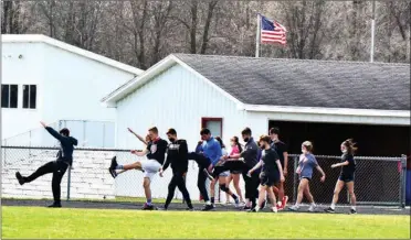  ?? PILOT PHOTO/RON HARAMIA ?? Boys and girls from the Glenn HS track team warm-up before a recent practice at the school. The first meet is this Thursday (weather permitting).