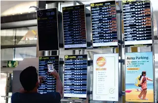  ?? XINHUA PHOTO ?? This Aug. 29, 2022 file photo shows a man taking pictures of flight informatio­n with his mobile phone at the Adolfo-Suarez-Barajas Airport in Spain’s capital Madrid.