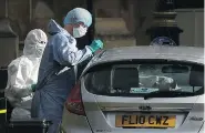  ?? LEON NEAL / GETTY IMAGES ?? Forensic officers work on the vehicle that crashed into security barriers outside the Houses of Parliament in London on Tuesday.