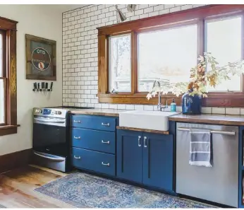  ??  ?? |BELOW RIGHT| OUT OF THE CLOSET. These massive windows let plenty of natural light into the completely renovated kitchen. While most of the home’s floors are original, these were laid by Angela’s dad with wood they found in an old closet.