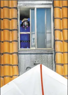  ??  ?? A crew member from Earth Resource Group Environmen­tal Services cleans salvageabl­e property that had been contaminat­ed by asbestos.