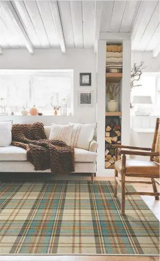  ?? ?? This Stewart clan tartan rug adds a warm, cosy and slightly sporty, masculine feel to your interior.