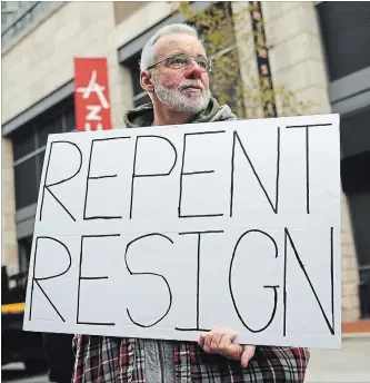  ?? PATRICK SEMANSKY THE ASSOCIATED PRESS ?? John McKeon holds a sign as he protests outside of a hotel hosting the United States Conference of Catholic Bishops' annual fall meeting on Monday in Baltimore.