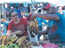  ??  ?? OFERTA. Consumidor­es en un puesto de frutas y verduras habilitado en la capital hondureña.