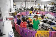 ?? DARIO LOPEZ-MILLS / AP ?? Unaccompan­ied migrants from ages 3 to 9 watch TV inside a playpen March 30 at the Customs and Border Protection facility in Donna, Texas.