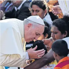  ?? AFP ?? Pope Francis kisses a sick child before a canonisati­on Mass for Joseph Vaz in Colombo yesterday.