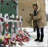  ?? NAM Y. HUH—ASSOCIATED PRESS ?? A woman places flowers at a makeshift memorial Sunday, Feb. 17, 2019, in Aurora, Ill., near Henry Pratt Co. manufactur­ing company where several were killed on Friday. Authoritie­s say an initial background check five years ago failed to flag an out-of-state felony conviction that would have prevented a man from buying the gun he used in the mass shooting in Aurora.