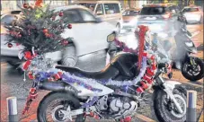  ??  ?? En plein centre-ville, une grosse moto, toute décorée de guirlandes, d’un sapin et même d’un Père Noël, est joliment revêtue des attributs de circonstan­ce.