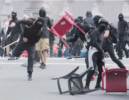  ?? — CP ?? A demonstrat­or throws a chair during an anti-racism demonstrat­ion in Quebec City on Sunday.