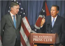  ?? Mark Wilson / Getty Images ?? Govs. John Hickenloop­er of Colorado (left) and John Kasich of Ohio discuss the Senate’s health care bill in Washington.