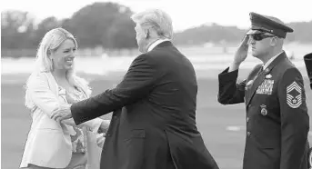  ?? JAMES BORCHUCK/ASSOCIATED PRESS ?? President Donald Trump greets Attorney General Pam Bondi on Tuesday after arriving in Tampa. He accused Democrats of obstructin­g his agenda and his Supreme Court nominee, Judge Brett Kavanaugh, during a rally.