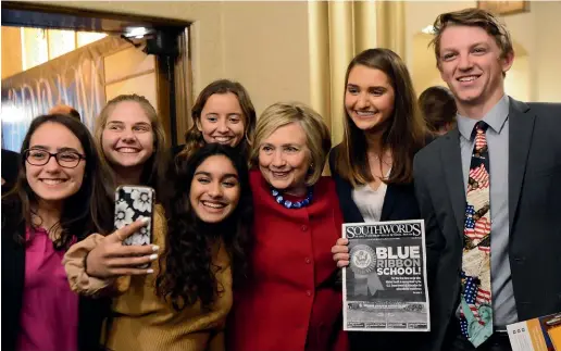  ?? AP ?? Former Secretary of State Hillary Clinton joins high school student journalist­s for photos after speaking during the Trailblazi­ng Women of Park Ridge event in Park Ridge, Illinois.