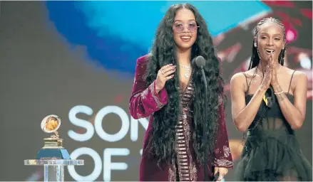  ?? ROBERT GAUTHIER/LOS ANGELES TIMES ?? H.E.R., left, and Tiara Thomas accept the Grammy award for song of the year at the Grammys on March 14 in Los Angeles.