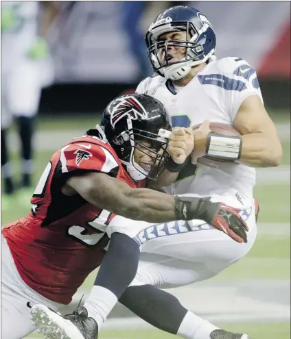  ?? DAVE MARTIN/ THE ASSOCIATED PRESS ?? Seahawks quarterbac­k Russell Wilson is sacked by Falcons linebacker Akeem Dent during NFC divisional playoff game Sunday.