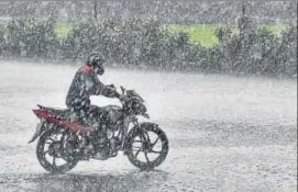  ??  ?? A commuter rides a bike as heavy rains accompanie­d by hailstorm lashed parts of the national capital, near Vijay Chowk in New Delhi on Saturday. PTI