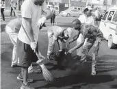  ??  ?? Volunteers clean up debris Saturday in Lagos, Nigeria.