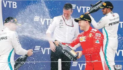  ??  ?? Celebració­n. Lewis Hamilton, su compañero Valteri Bottas y Sebastian Vettel se rocean con champaña en el podio.