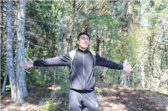  ??  ?? Ayman Al-Sultan, 19, breathes in the wooded surroundin­gs in East Sooke Park. He sees himself playing soccer for the Vancouver Whitecaps.