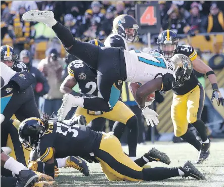  ?? ROB CARR/GETTY IMAGES ?? Jacksonvil­le Jaguars running back Leonard Fournette dives over the Pittsburgh Steelers defence into the end zone for a touchdown Sunday in Pittsburgh. Fournette rushed for 109 yards and three TDs in Jacksonvil­le’s 45-42 upset win over the Steelers.