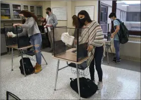  ?? JESSICA HILL — THE ASSOCIATED PRESS FILE ?? On March 18, students in teacher Christophe­r Duggan’s science class clean their work areas at the end of class at Windsor Locks High School in Windsor Locks, Conn.