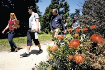  ?? Paul Chinn / The Chronicle ?? Volunteer services coordinato­r Chloe Wieland (left) leads a group of prospectiv­e volunteers on a tour of the botanical garden’s grounds at Golden Gate Park in San Francisco.