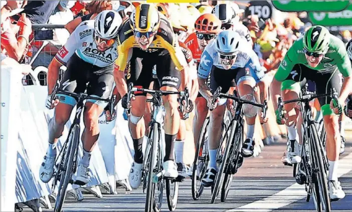  ??  ?? Caleb Ewan (casco rojo) se impone a Sam Bennett (de verde), mientras Peter Sagan (izquierda) forcejea con Wout van Aert, en el esprint de Poitiers.