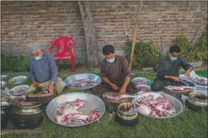  ??  ?? Kashmiri wazas, or chefs, chop mutton before cooking for a wedding feast wazwan.