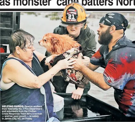  ??  ?? HELPING HANDS: Rescue workers from Township No. 7 Fire Department and volunteers from the Civilian Crisis Response Team ferry a woman — and her poor pooch — to safety in James City, NC, on Friday.