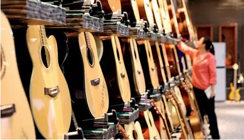  ?? Fotos de Yu Jie ?? Las maderas importadas de diferentes países se convierten en refinadas guitarras en Zheng’an.