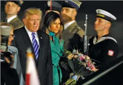  ?? AP PHOTO BY CZAREK SOKOLOWSKI ?? President Trump, right and the first lady Melania Trump walk past the honor guards as they arrive to Warsaw, Poland, Wednesday. President Donald Trump is back to Europe hoping to receive a friendly welcome in Poland despite lingering skepticism across...