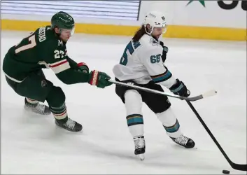  ?? AP Photo/Stacy Bengs ?? San Jose’s Erik Karlsson (65) handles the puck against Minnesota Wild’s Nick Bjugstad (27) in the third period of an NHL hockey game on Sunday in St. Paul, Minn. San Jose won 5-3.